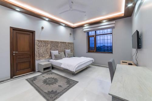 a bedroom with a bed and a tv in it at The Almond Tree in Jodhpur