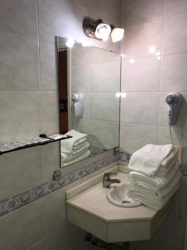 a bathroom with a sink and a mirror and towels at Loft Argentino Apart Buenos Aires in Buenos Aires