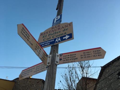 a street sign with several signs on a pole at Apartaments Cal Climent in Fornols