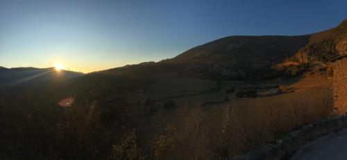 a sunset over a mountain with the sun setting on the horizon at Apartaments Cal Climent in Fornols