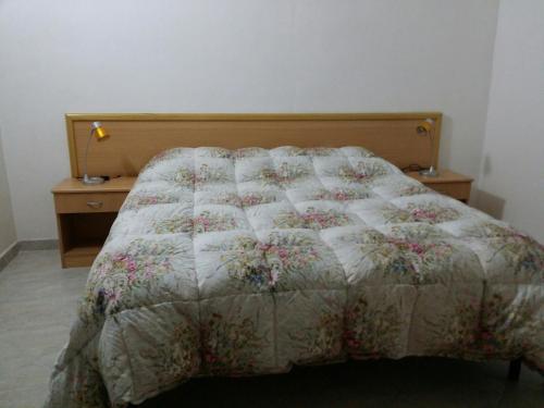 sypialnia z łóżkiem z kołdrą w obiekcie Residence Polidoro w mieście Vieste