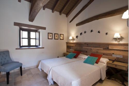 a bedroom with two beds and a blue chair at Via Avis in Santa Catalina de Somoza