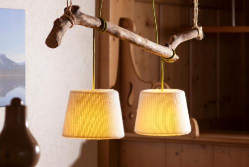 two lights hanging from a wall with a stick at Alpenlodge Pfronten in Pfronten
