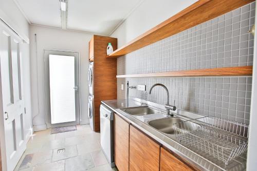 a kitchen with a sink and a dishwasher at Laanhof Victorian House Self-Catering in Stellenbosch