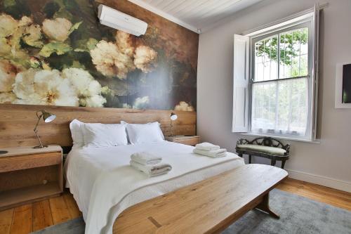 a bedroom with a bed with a painting on the wall at Laanhof Victorian House Self-Catering in Stellenbosch