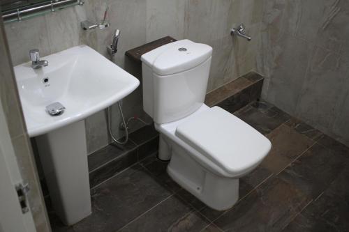 a bathroom with a white toilet and a sink at Gem Field Rest in Ratnapura