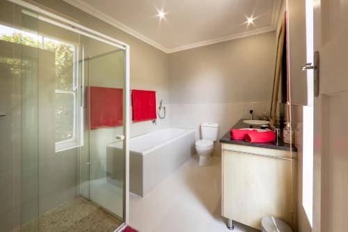 uma casa de banho com uma banheira, um WC e um chuveiro em B's Place em Port Elizabeth