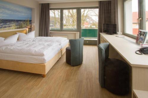 a hotel room with a bed and a desk at Hotel Haus am Meer in Graal-Müritz