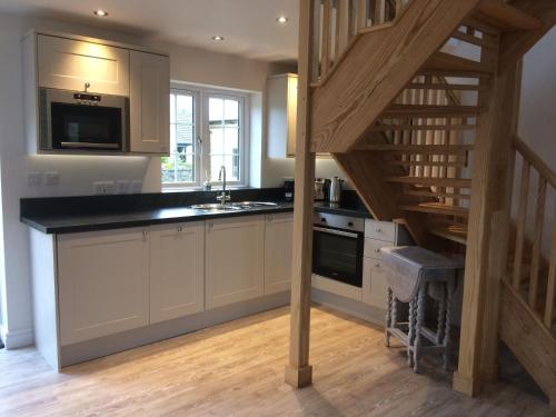a kitchen with a staircase leading up to a loft at Rosebank Barn in Brentor
