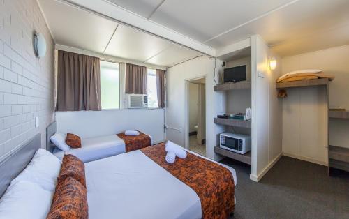 a hotel room with two beds and a tv at The Australian Hotel Murgon in Murgon