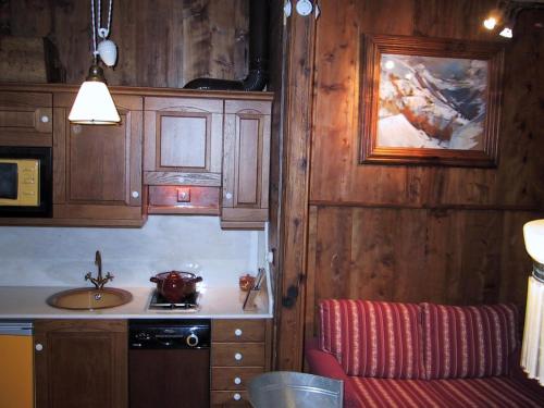 a kitchen with wooden cabinets and a sink at La Llúpia in Isavarre