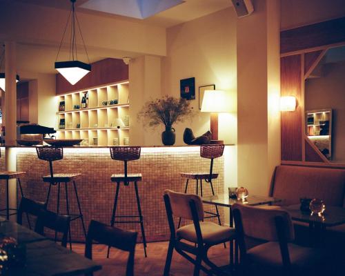 パリにあるオテル ハビチュエルのテーブルと椅子のあるレストランのバー