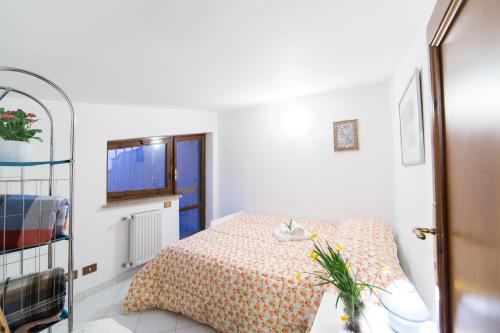 a white room with a bed with a table and a window at Frascati Country House in Grottaferrata