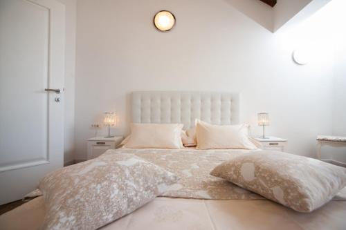 a white bedroom with a large bed with pillows at Luxury Villa Kate - in Lucice Bay with turquoise sea, Amazing Seaviews, and Heated Pool in Milna