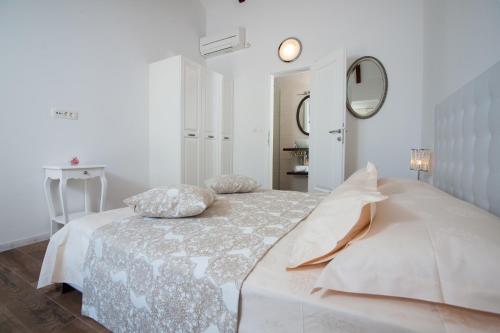 a white bedroom with a bed and a mirror at Luxury Villa Kate - in Lucice Bay with turquoise sea, Amazing Seaviews, and Heated Pool in Milna