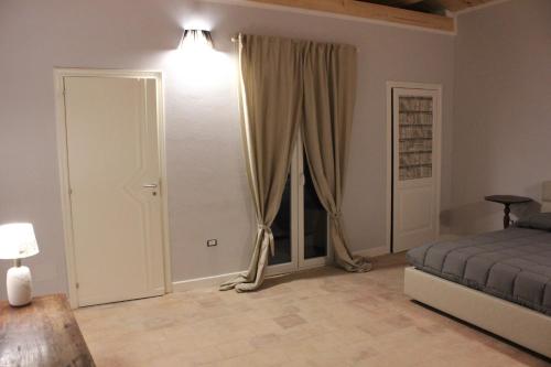 sypialnia z łóżkiem i dużym oknem w obiekcie Borgo Dauno-Il Rifugio w mieście Volturara Appula