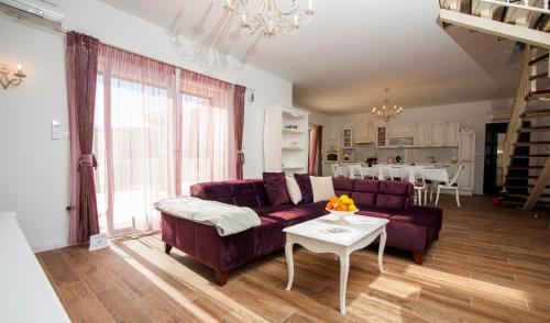 a living room with a purple couch and a table at Luxury Villa Kate - in Lucice Bay with turquoise sea, Amazing Seaviews, and Heated Pool in Milna