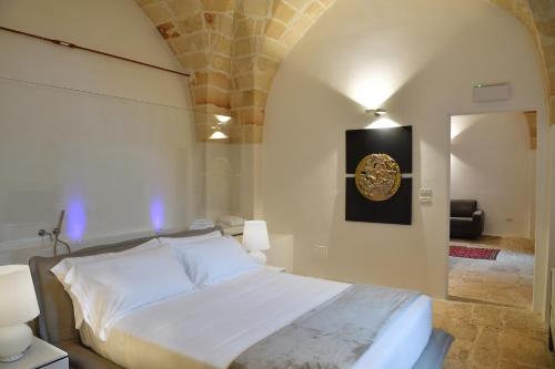 a bedroom with a bed and a painting on the wall at Masseria Li Reni in Manduria