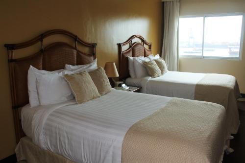 a hotel room with two beds and a window at Radisson Colon 2,000 Hotel & Casino in Colón