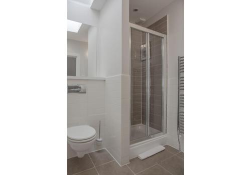 La salle de bains est pourvue d'une douche et de toilettes. dans l'établissement The Skyline - The Edinburgh Address, à Édimbourg