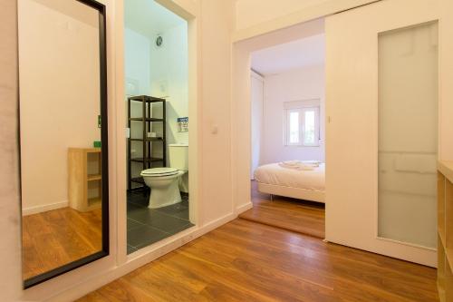 a bathroom with a toilet and a bedroom at Typical Tailor Made Flat in Central Graça in Lisbon