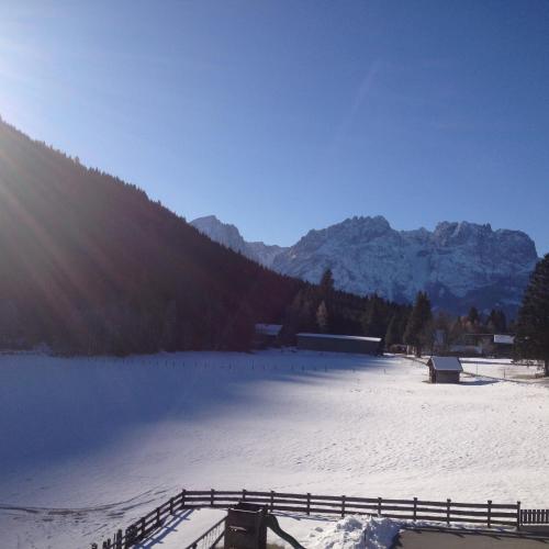 a snow covered field with a fence and mountains at Ferienwohnung Traumblick Dolomiten in Winklern
