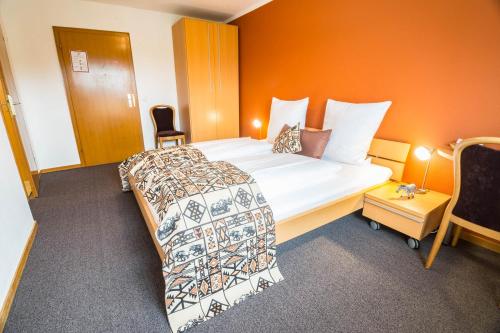 a bedroom with a large bed with an orange wall at Haus Mühlenbrock in Schermbeck