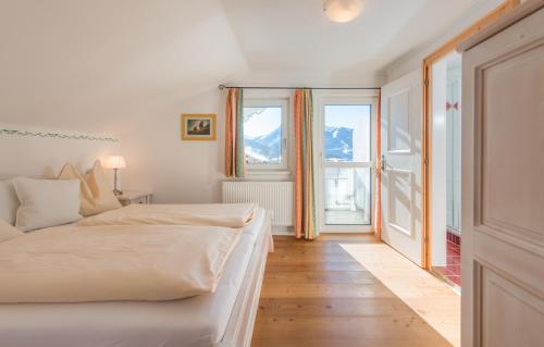 ラムサウ・アム・ダッハシュタインにあるLandhaus & Ferienwohnungen Bergrastのベッドと大きな窓のある寝室
