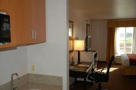 una camera d'albergo con scrivania e sedia di Holiday Inn Express Hotel & Suites Fenton/I-44, an IHG Hotel a Fenton