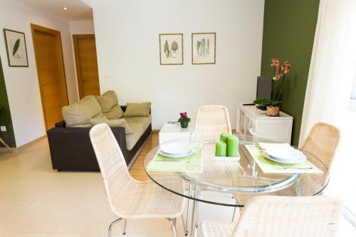 a living room with a glass table and chairs at Apartamentos El Palmeral de Madaria in Alicante