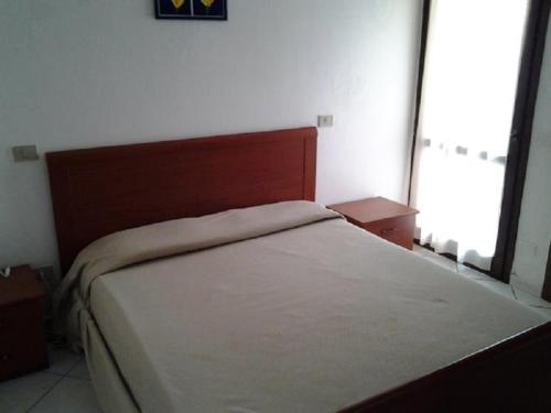 un letto in una camera da letto con una grande finestra di Appartamento 89 a Torre Dei Corsari