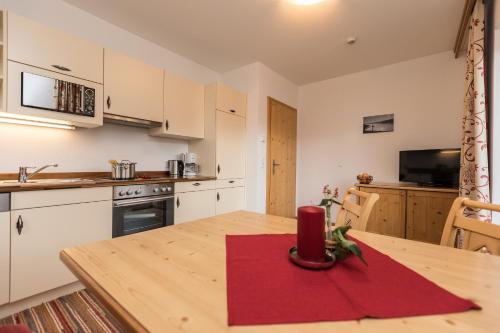 a kitchen with a wooden table with a red candle on it at Alpenhof Apartments in Mittersill