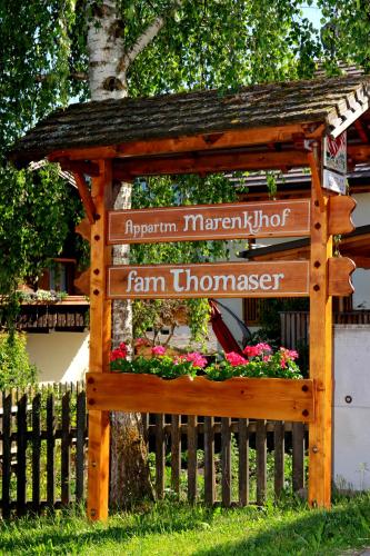 a sign for a farm entrance with flowers on a fence at Marenklhof in Tesido