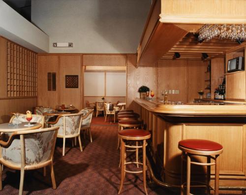 un restaurante con mesas y sillas y un bar en Auberge De La Baie, en Caraquet