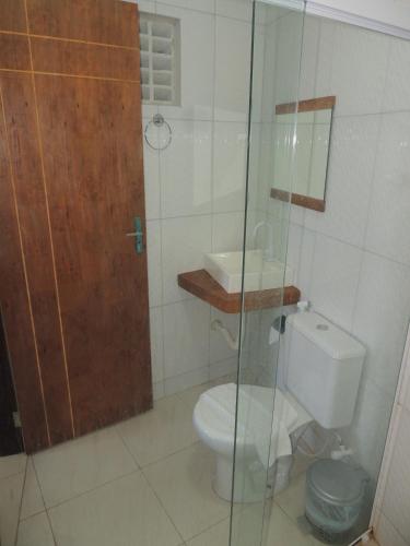 a bathroom with a toilet and a glass shower at Pousada Quinta do Patacho in Pôrto de Pedras