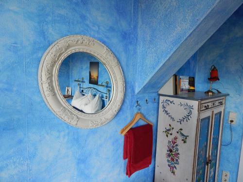 een blauwe kamer met een spiegel en een koelkast bij Kornspeicher Himmelpfort in Himmelpfort