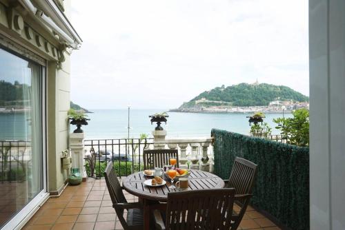 a table on a balcony with a view of the ocean at BREATHTAKING TERRACE VIEWS in luxury apartment - by www,SanSebastianApartments,es in San Sebastián