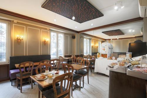 une salle à manger avec des tables et des chaises dans un restaurant dans l'établissement Grand Hôtel Des Gobelins, à Paris