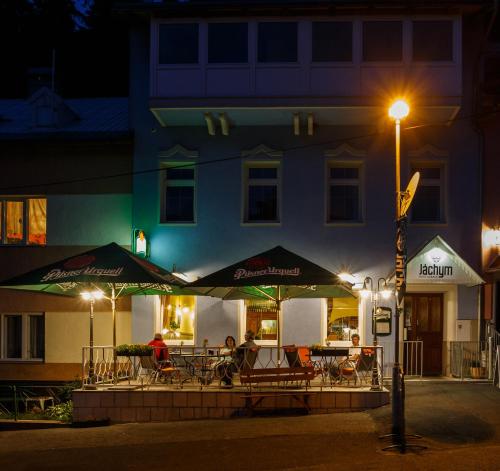 a restaurant with tables and umbrellas in front of a building at Hotel Orix in Jáchymov