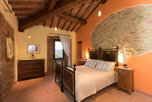 a bedroom with a bed and a stone wall at Podere Molinaccio in Panicale