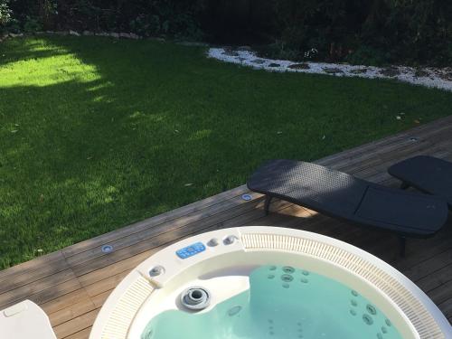 a hot tub on a deck next to a chair at Chambres d'Hôtes Au coin du spa in Boulogne-sur-Mer