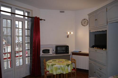 a small kitchen with a table and a microwave at La Précieuse in Mers-les-Bains