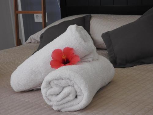 a towel with a flower on top of a bed at Las Flores studio 3 in Playa de las Americas