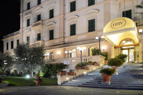a large building with stairs in front of it at night at Grand Hotel Vittoria in Montecatini Terme