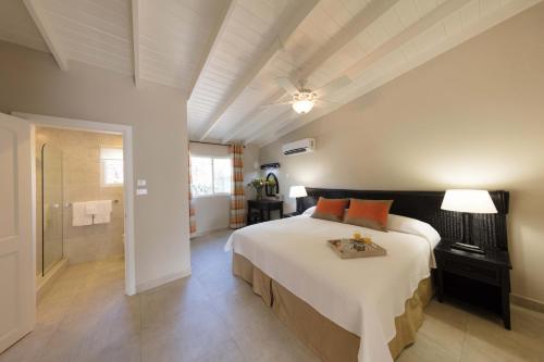 a bedroom with a large bed and a bathroom at All Seasons Resort in Saint James