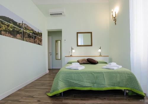 a bedroom with a green bed with two towels on it at Colors of Cinque Terre - Guest House in La Spezia