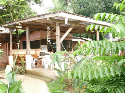 a wooden pavilion with tables and chairs in a garden at Jacobin Hostel & Cabins in Drake