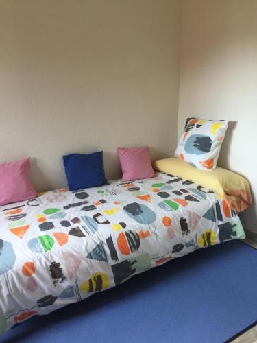 a bed with a colorful comforter and pillows on it at CASA EL CASTAÑÉU in Arriondas