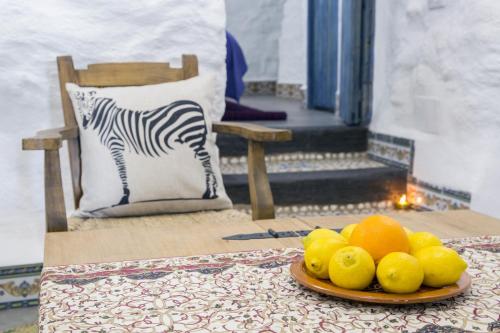 un piatto di frutta su un tavolo con un cuscino zebrato di Balcones de Piedad a Los Balcones