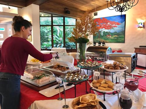 a woman standing in front of a buffet of food at Hotel Bougainvillea San José in Santo Domingo